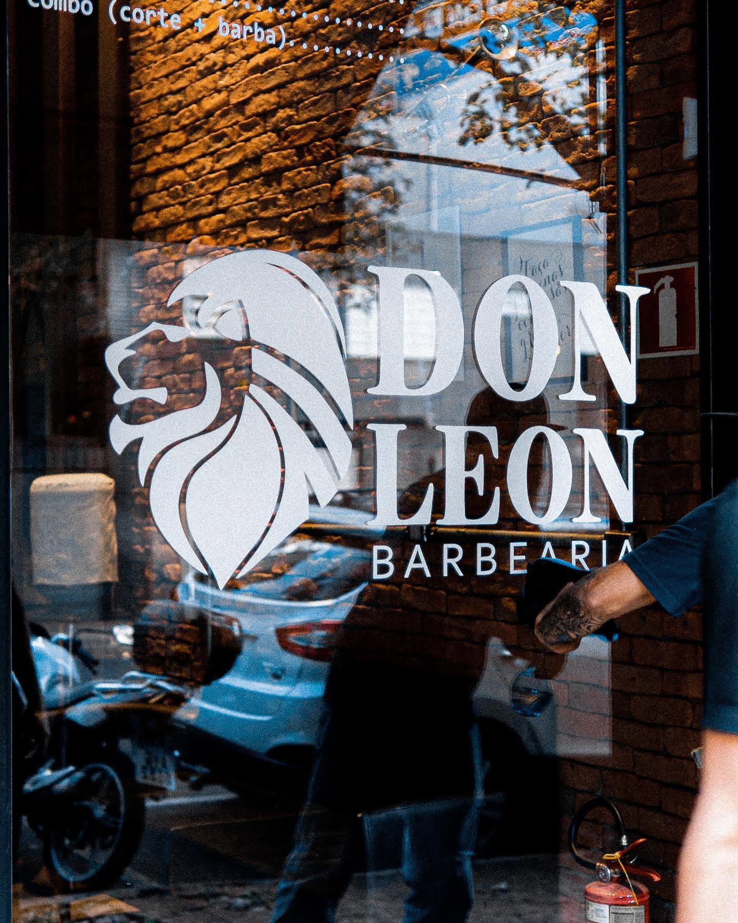 Logo do leão Don Leon na vitrine da barbearia